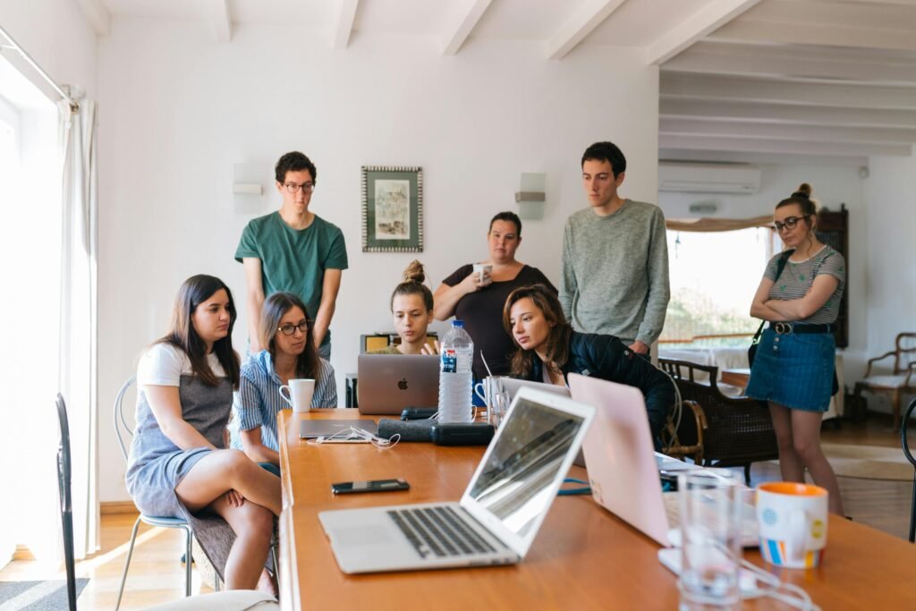 pexelshillaryfox1595385 Beawareofmecom Group of people gathered around a table looking at laptops and discussing the subject of Mental Health in the Workplace