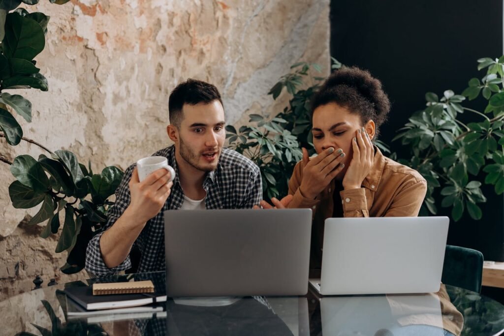 Financial Inequality in Relationships How Money Impacts Mental Health and What to Do About It 2 Beawareofmecom A young couple looking distressed and surprised while viewing something on a laptop screen with the woman covering her mouth in shock and the man holding a coffee cup