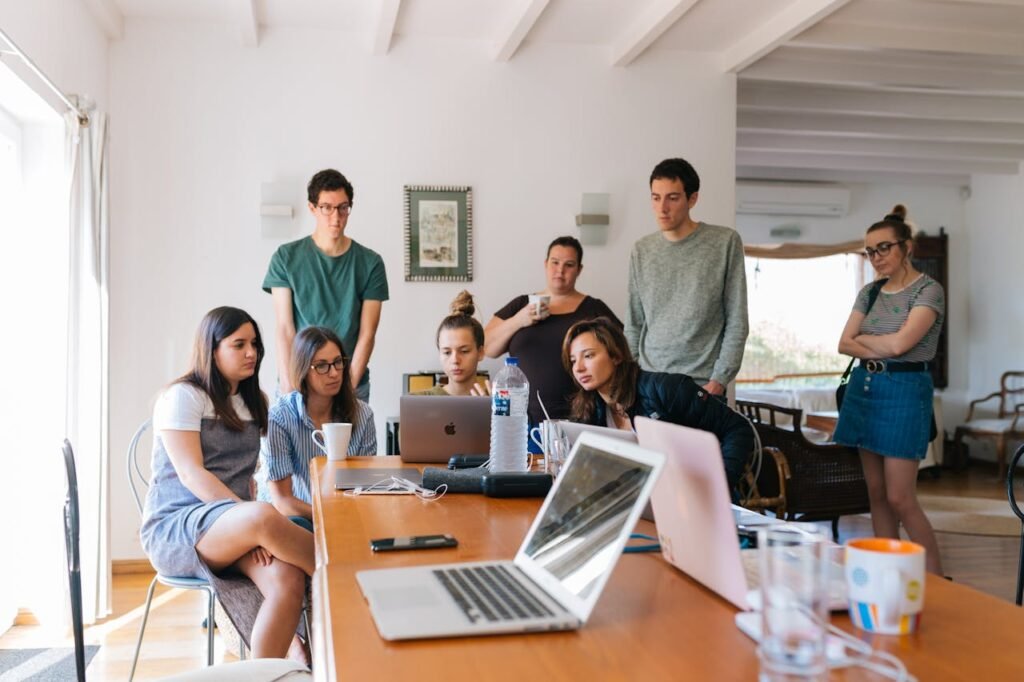 Tips for Managing Stress at Work 4 Beawareofmecom A diverse group of coworkers discussing ideas around a table emphasizing teamwork and delegation in a work setting