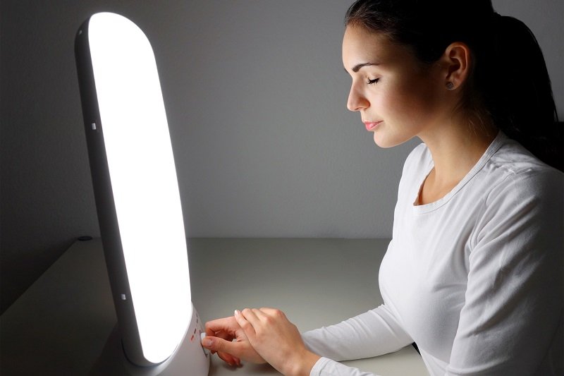 Individual using a light therapy box to manage seasonal depression during winter Beawareofmecom Individual using a light therapy box to manage seasonal depression during winter