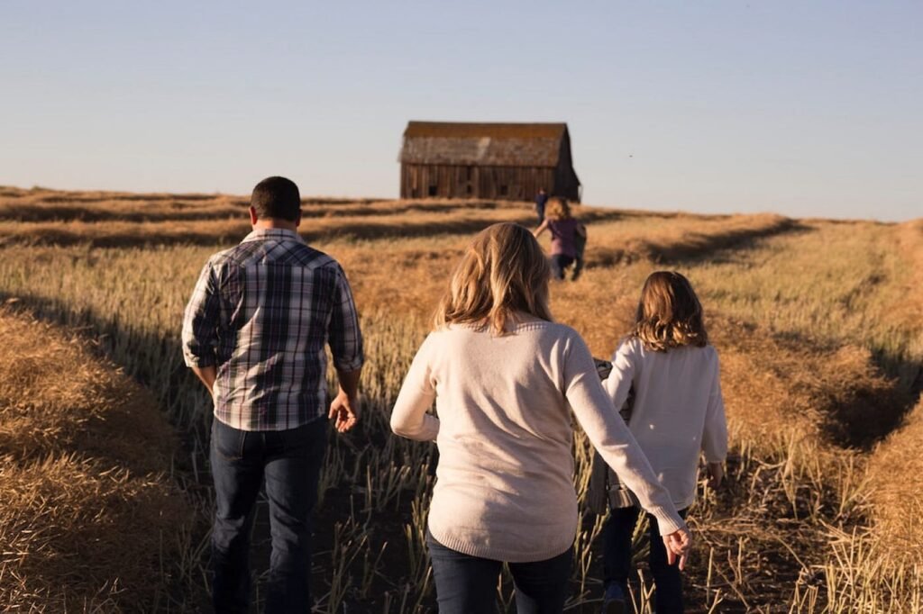 Emotional Development Beawareofmecom A family walks together through a peaceful field toward a barn at sunset, reflecting how gentle parenting actually affects kids by fostering secure attachment, connection, and family bonding in nature.