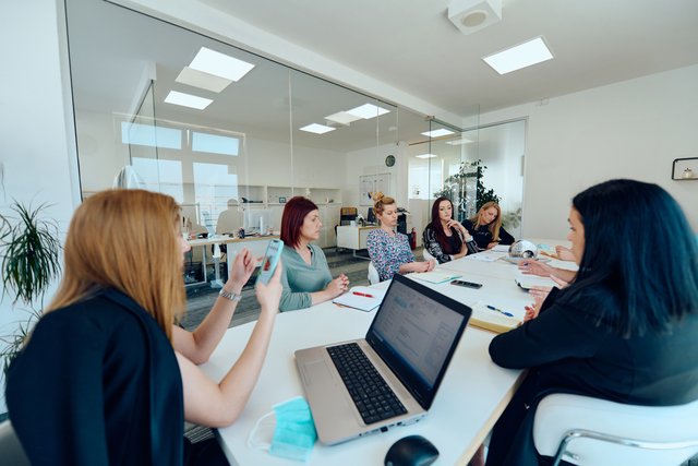 Diverse Business Team Discussing Projects in a Modern Glass Office Beawareofmecom Supportive Work Environment