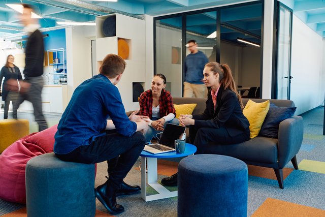 Multiethnic startup business team on meeting in a modern bright open space coworking office Brainstorming working on laptop Group of coworkers walking around in motion blur Beawareofmecom Supportive Work Environment